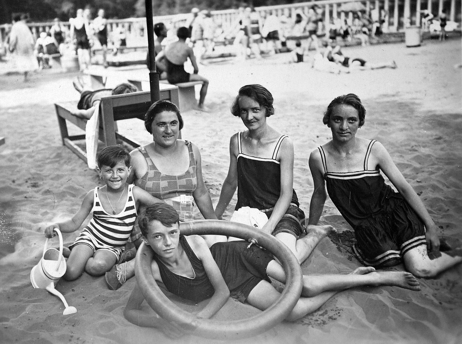 Black and white archive photo from 1923 showing women and children in period swimsuits sitting on the sand at the Árpád strandfürdő open-air bath in Békéscsaba