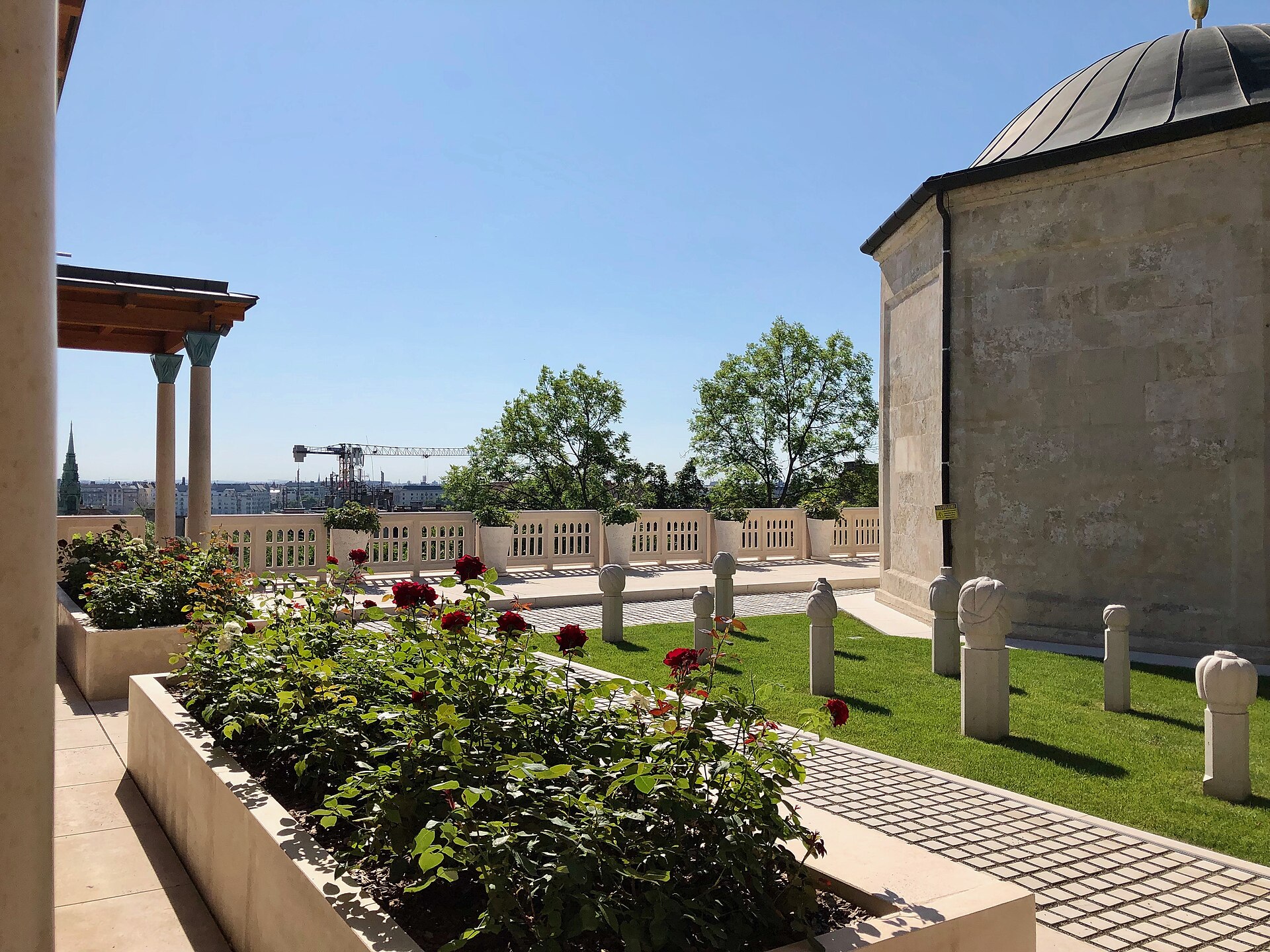 Rose beds and carved stone posts on the terrace beside the domed türbe of Gül Baba in Budapest