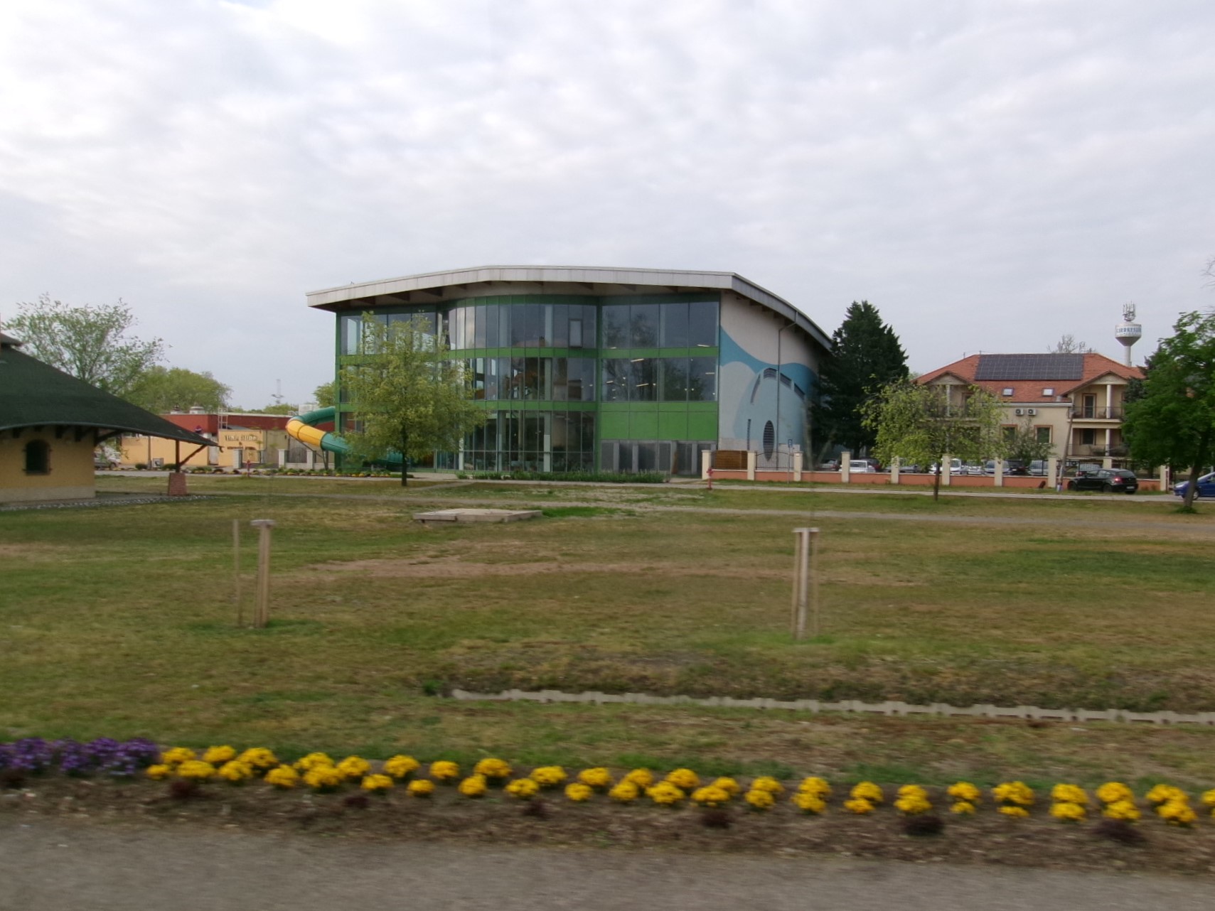 The covered winter bath hall at Cserkeszolo, curved roof and green glass facade, seen from main road 44