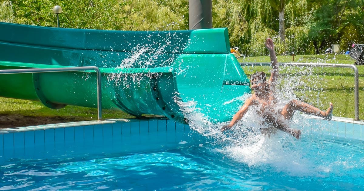 A swimmer landing from the outdoor water slide at Árpád Gyógy- és Strandfürdő