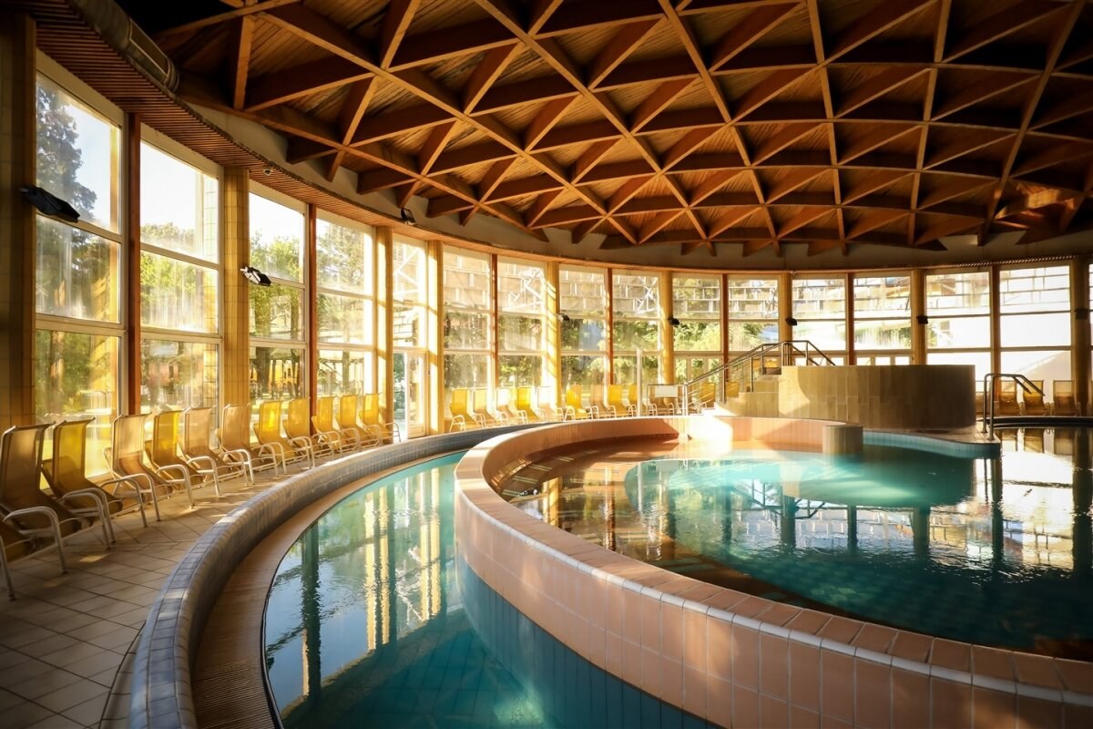 The indoor pool beneath a timber roof at Bükfürdő Thermal & Spa.