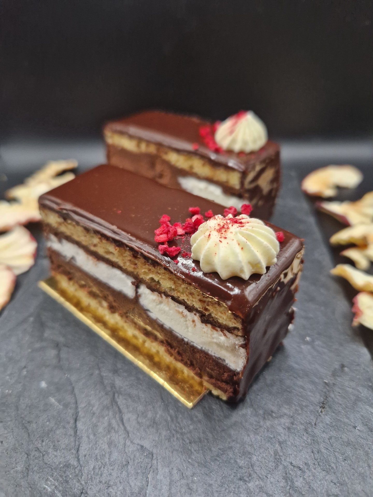 Una fetta di torta a strati con glassa al lampone e cioccolato dalla vetrina di Geraldine