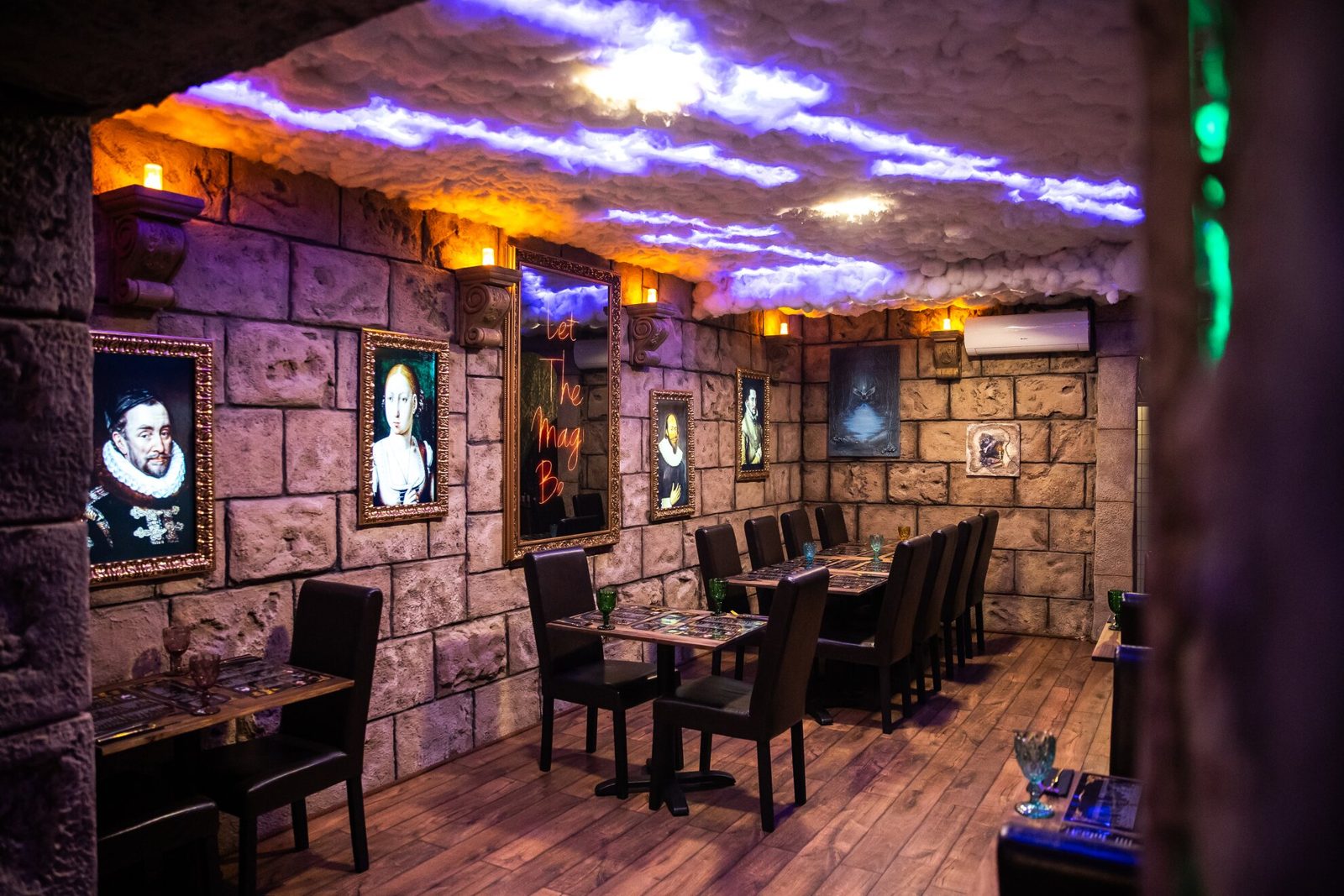 קירות אבן עם דיוקנאות ממוסגרים ושלט ניאון The Magic דולק בדה מג’יק 2 ברחוב Nagymező utca