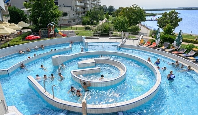 בריכת השעשועים החיצונית של Velence Resort & Spa, עם אגם ולנצה ברקע
