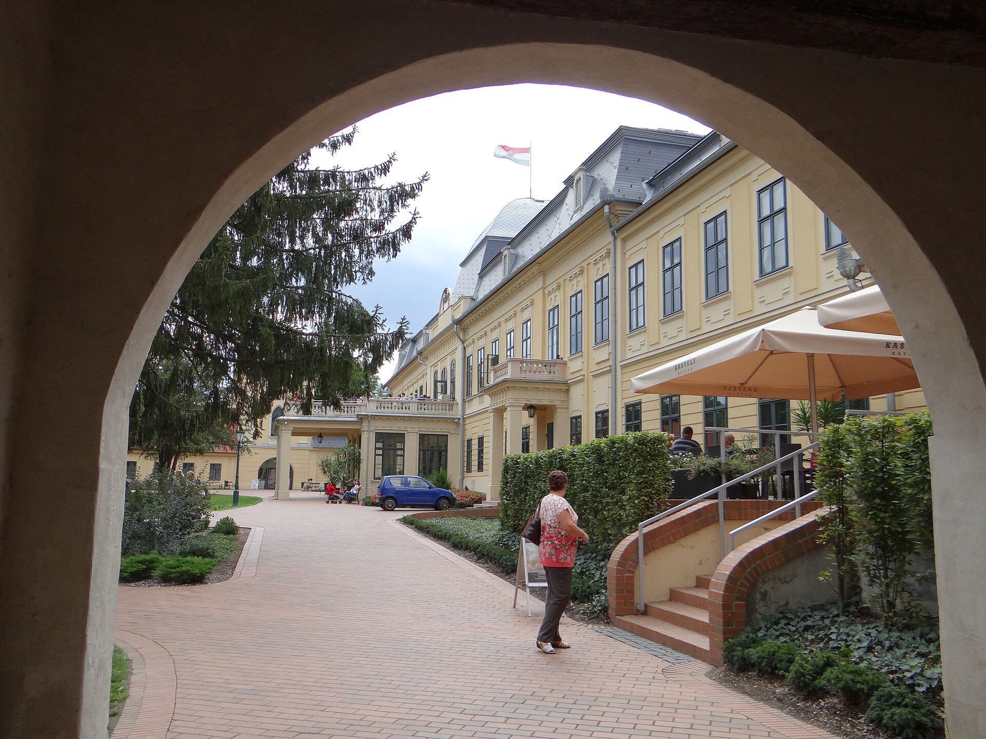 The yellow facade of the Almásy mansion in Gyula, seen through an archway