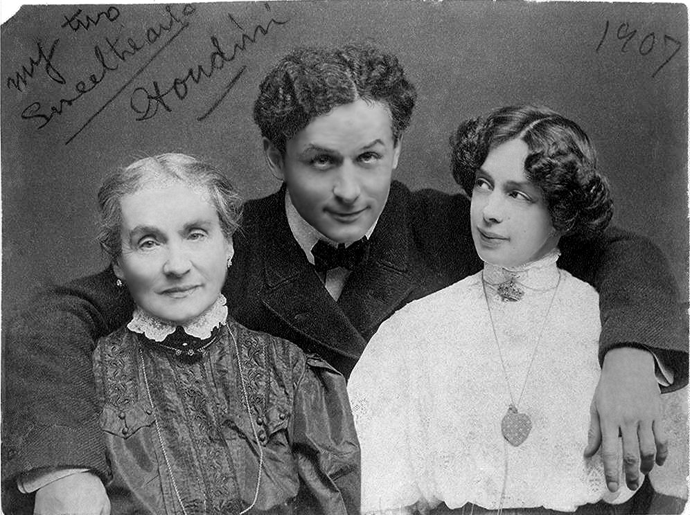 Harry Houdini with his arms around his mother Cecília on the left and his wife Bess on the right, a photo he signed my two sweethearts in 1907
