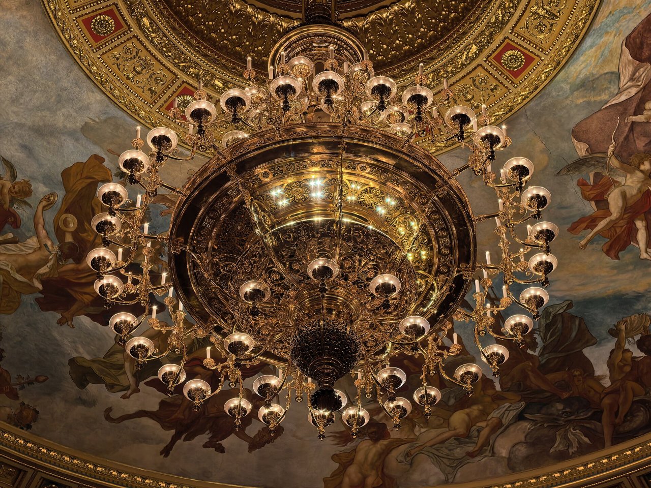 The painted ceiling and bronze chandelier above the auditorium of the Hungarian State Opera House, photographed in 2025