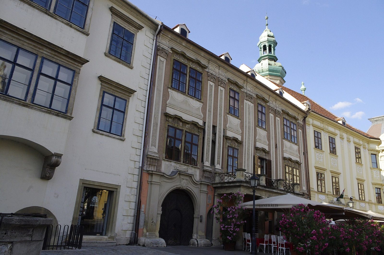 Baroque houses on Fő tér in Sopron, with the green helmet of the Firewatch Tower rising behind them