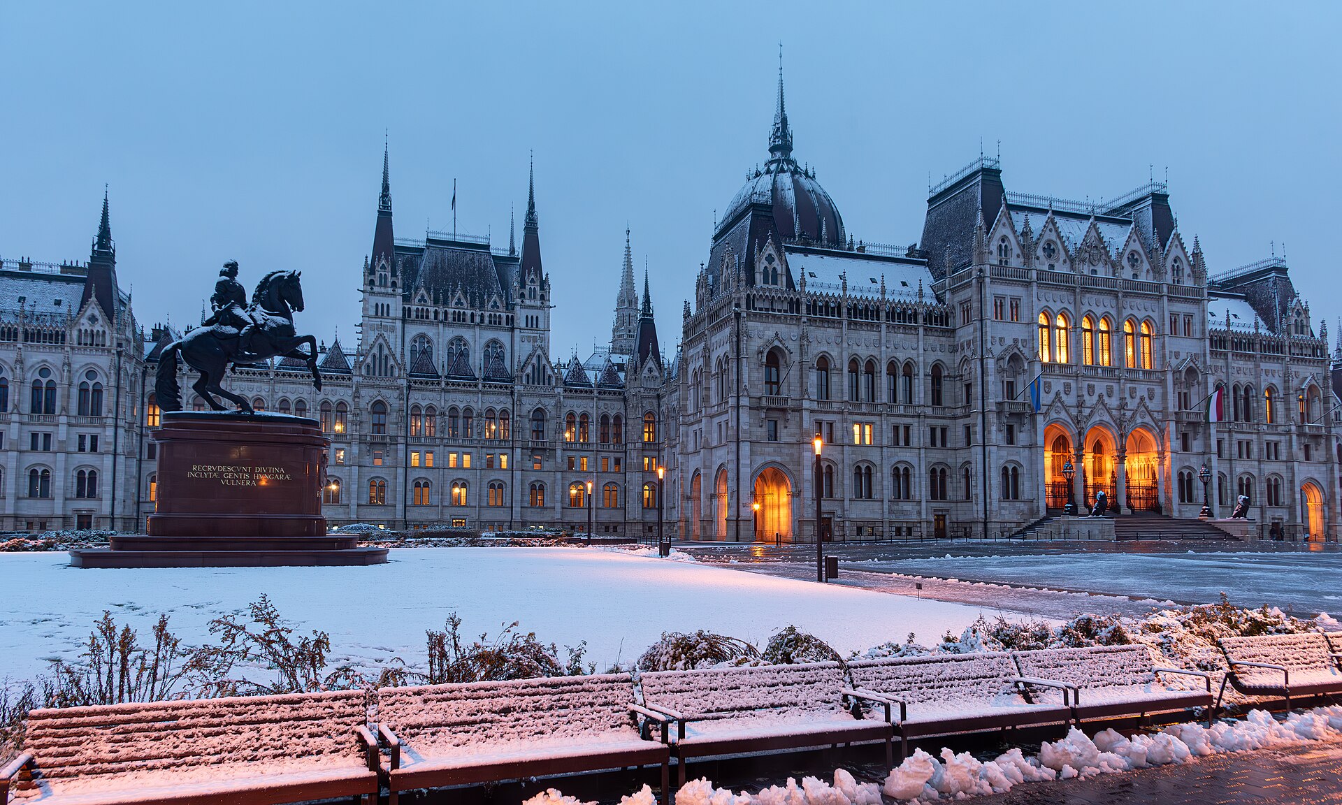 Hungarian Parliament Building covered in snow during a Budapest winter evening with golden lights